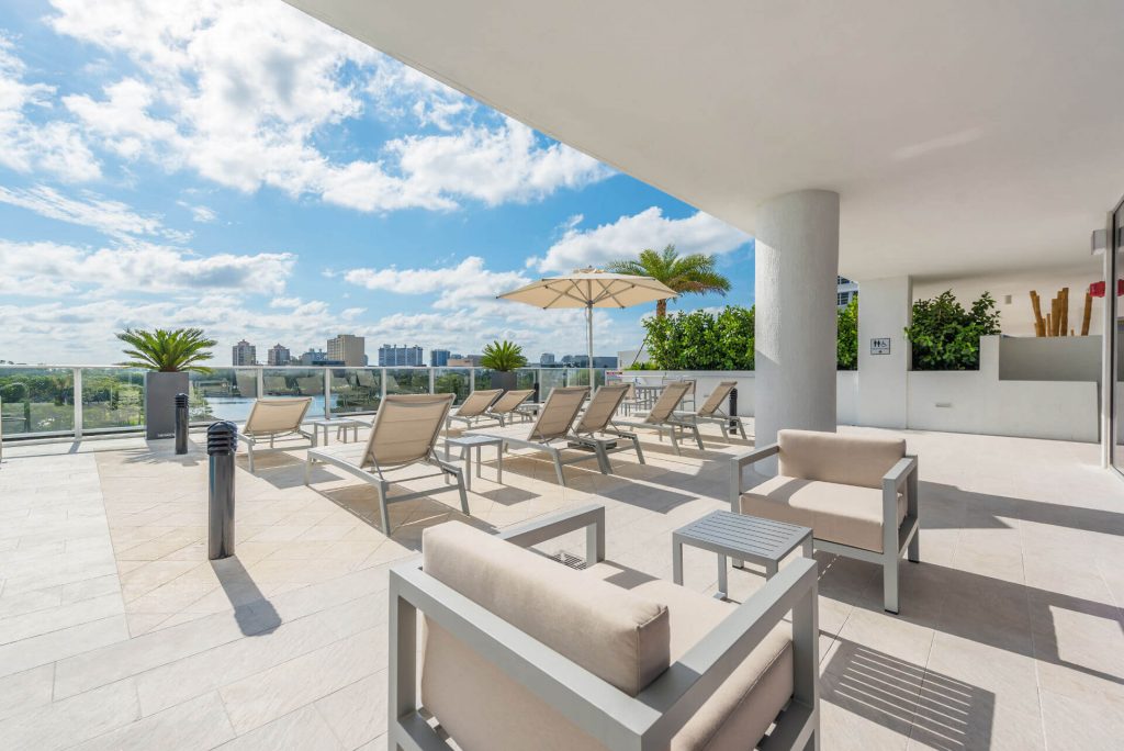 Riverfront Pool deck with modern outdoor furniture under overhang